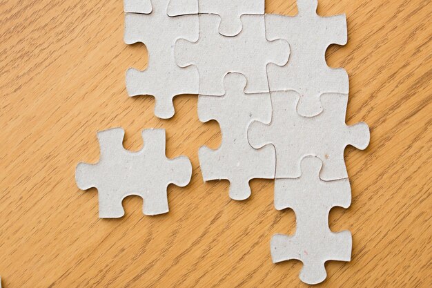 business and connection concept - close up of puzzle pieces on wooden surface