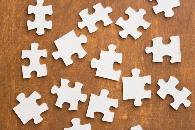 business and connection concept - close up of puzzle pieces on wooden surface