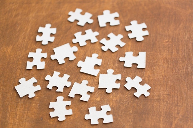 business and connection concept - close up of puzzle pieces on wooden surface