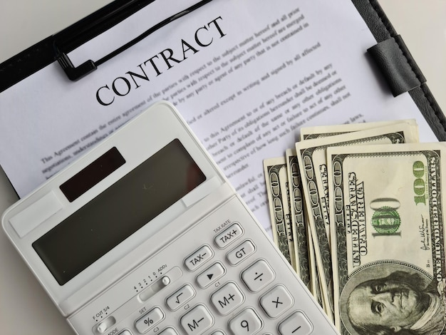 Business contract one hundred dollar bills and calculator