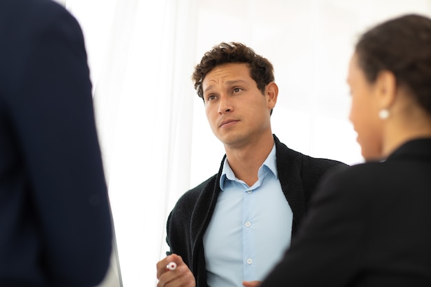 Business corporate leadership concept. Handsome cheerful hispanic creative business man speaking in meeting at workspace office. Portrait