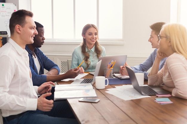 Business corporate meeting of young successful team with female boss. Office discussion, communication with partners, copy space