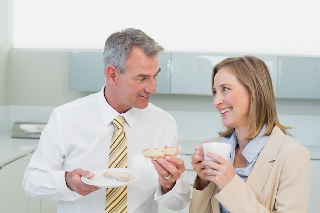 Business couple having breakfast in kitchen