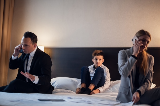 A business couple in a hotel room with their son