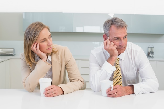 Business couple not talking after an argument in kitchen