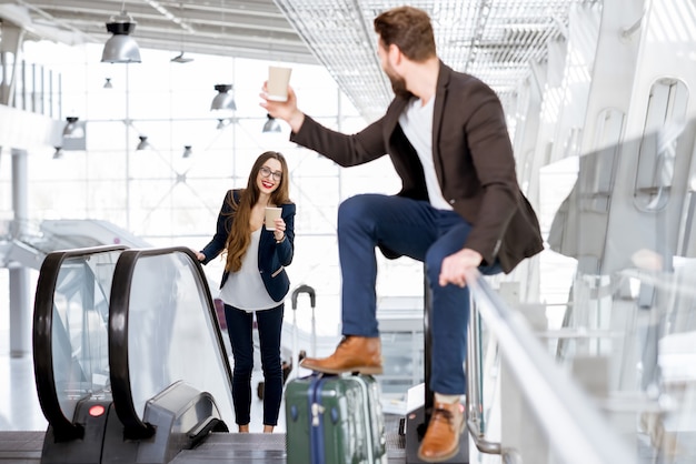 Business couple with coffee to go at the airport. Business travel concept