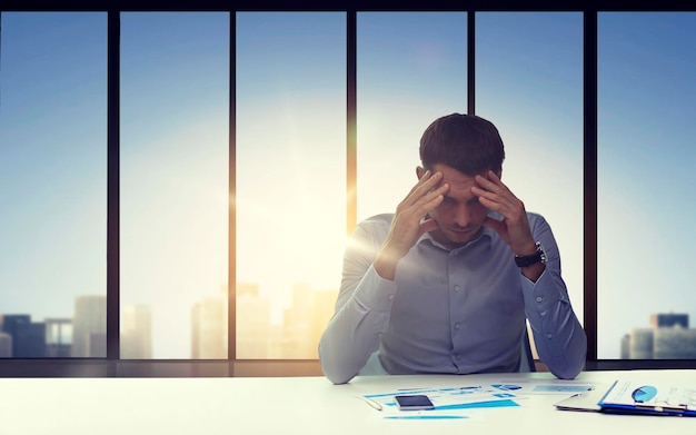 business, deadline, fail, people and stress concept - close up of anxious businessman with papers and smartphone