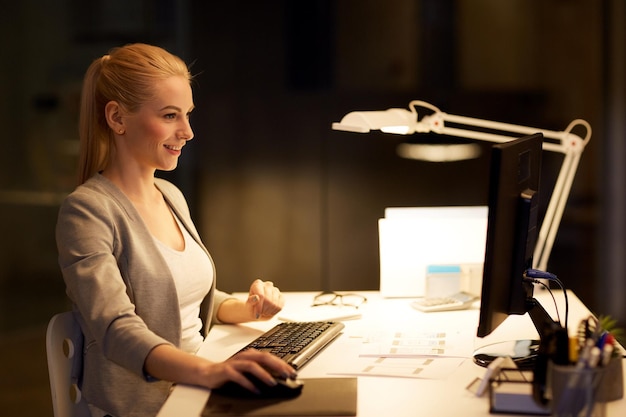 Foto business deadline e concept tecnologico donna d'affari con computer che lavora in ufficio notturno