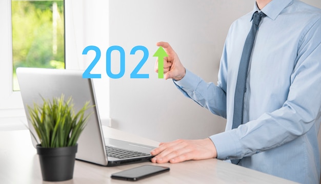 Foto sviluppo del business verso il successo e crescita del concetto dell'anno 2021. pianificare il grafico della crescita aziendale nel concetto dell'anno 2021. piano dell'uomo d'affari e aumento degli indicatori positivi nella sua attività.