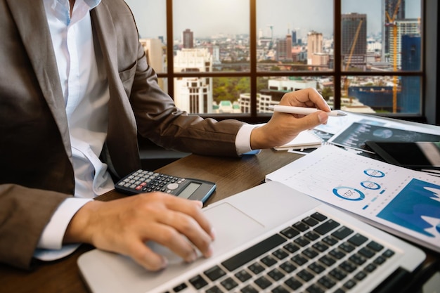 business documents on office table with smart phone and digital tablet and graph financial and woman working