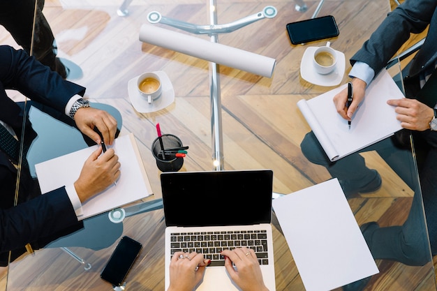 Business documents on office table with smartphone and laptop