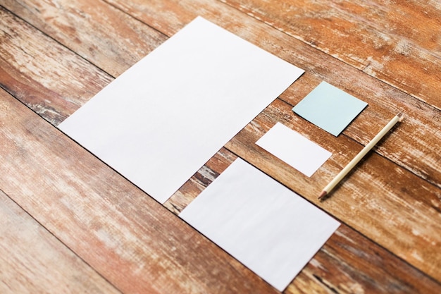 Photo business and education concept - blank paper sheets and pencil on wooden board or table