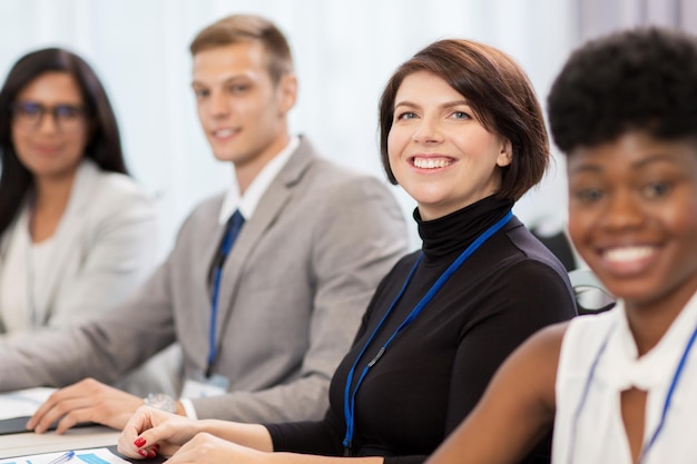 business and education concept - group of happy people at international conference