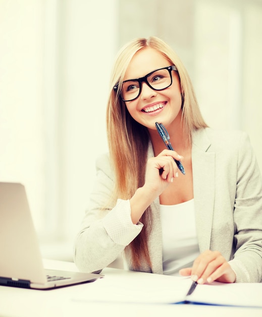 business and education concept - indoor picture of smiling woman with documents and pen