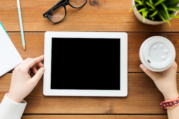 비즈니스, 교육, 기술, 사람 및 광고 개념 - 빈 태블릿 PC 화면과 나무 테이블에 커피가 있는 여성 가까이