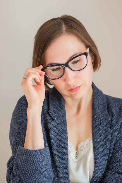 business European woman in blue costume and with glasses close up