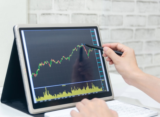 Photo a business examines the financial graph of sales growth on the computer