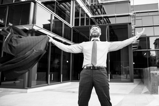 Photo business excitement business man keeping arms raised and expressing positivity outdoors businessman