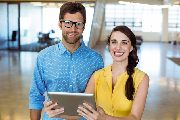 Business executive and co-worker holding digital tablet