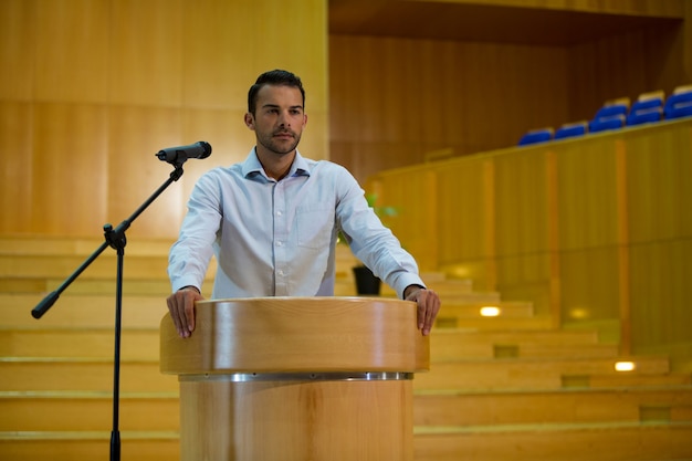 Photo business executive giving a speech at conference center