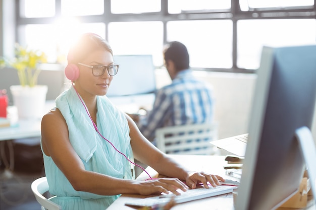 Uomo d'affari che ascolta la musica mentre si lavora al computer