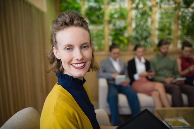 Business executive smiling while sitting in office lobby