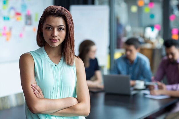 Business executive standing with arms crossed in office