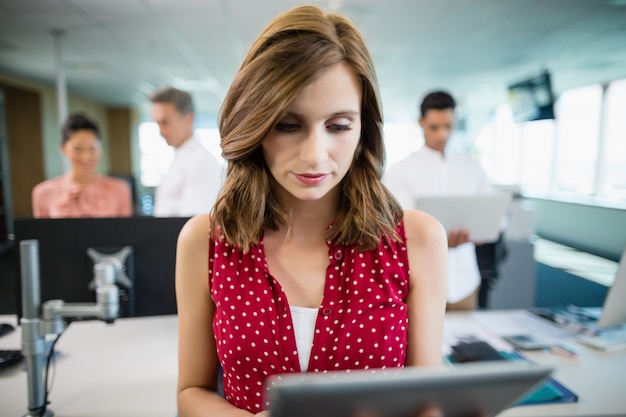 Business executive using digital tablet at desk