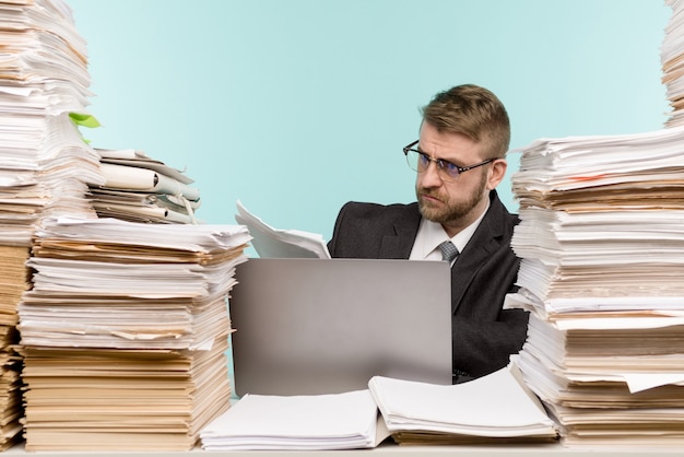 Business executive working in the office and piles of paperwork