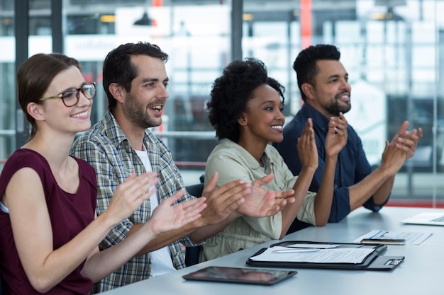 Business executives clapping in meeting at office