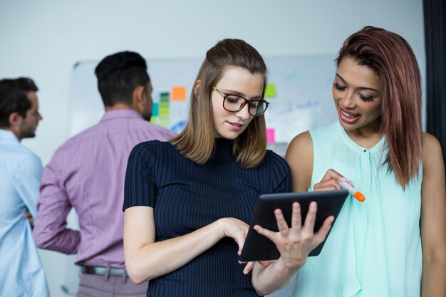 Business executives discussing over digital tablet