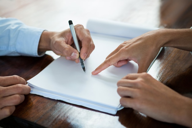 Business executives discussing documents during meeting