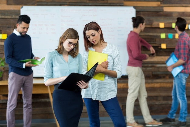 Business executives discussing over file during meeting