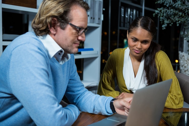 Business executives discussing over laptop