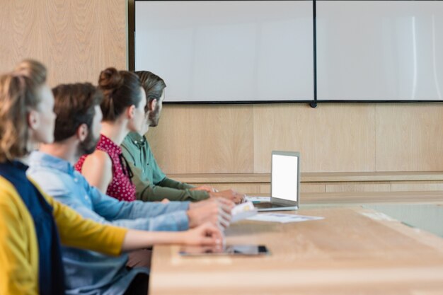 Photo business executives listening to a presentation in conference room