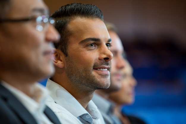 Business executives listening to speech at conference center