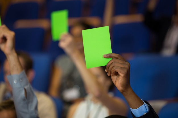 Photo business executives show their approval by raising hands at conference center