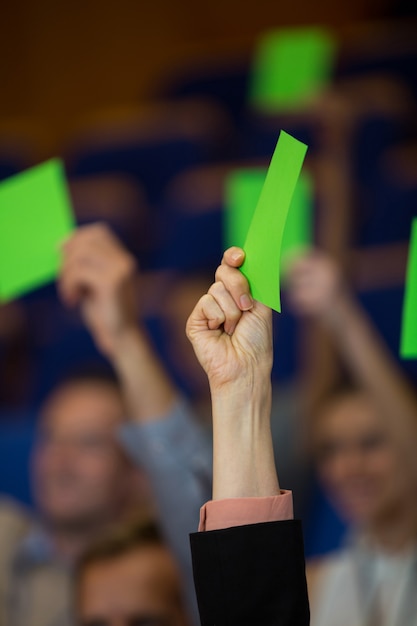 business executives show their approval by raising hands at conference center