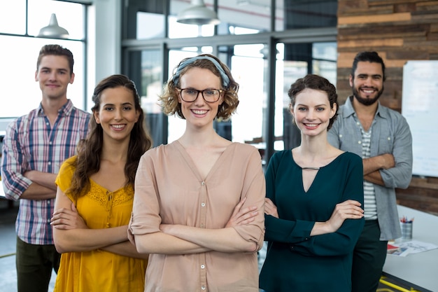 Business executives standing with arms crossed in office