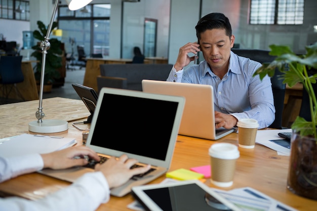 Business executives using laptop at desk