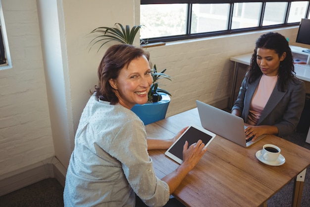 Business executives using laptop and digital tablet