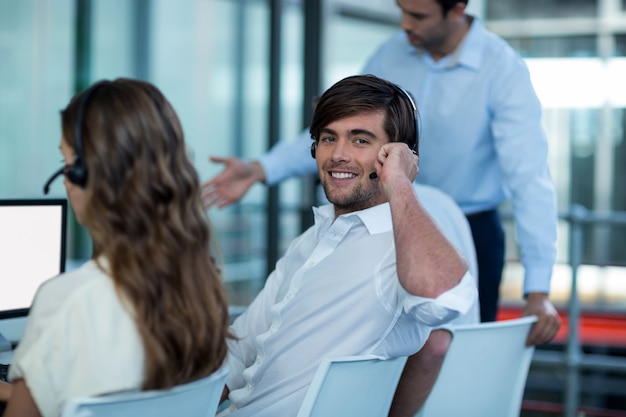 Business executives with headsets using computer