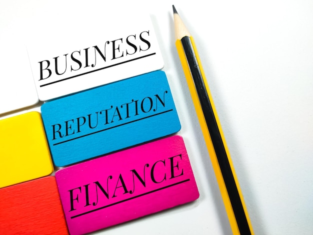 Photo business and finance concept text businessreputationfinance on colorful wooden board and pencil on white background