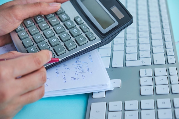 Business and finance conceptwomen work with calculator and laptoppen and notebook on the wooden table