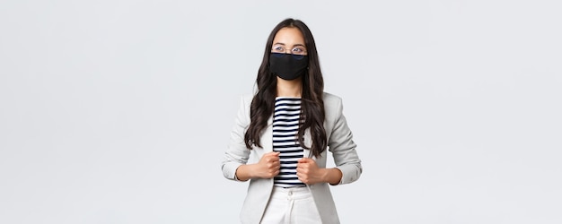 ウイルスと社会的距離の概念を防ぐビジネスファイナンスと雇用covid19自信を持って見上げる会議を持っているコロナウイルスに対するマスクのスタイリッシュでエレガントな女性起業家