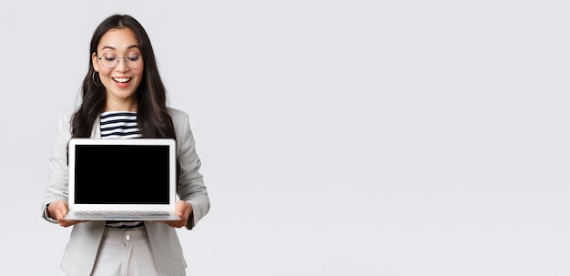 Business finance and employment female successful entrepreneurs concept Enthusiastic businesswoman in suit and glasses showing presentation demonstrate her project on laptop screen