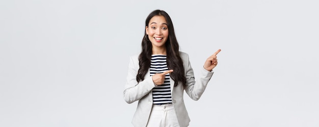 Business finance and employment female successful entrepreneurs concept Friendlylooking cute female office manager glad to help pointing upper right corner showing way and smiling