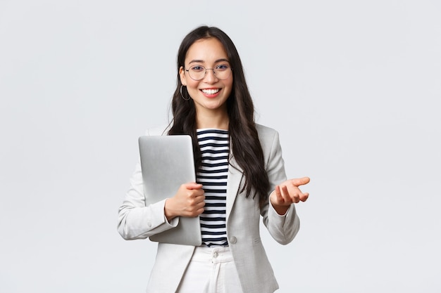 Photo business, finance and employment, female successful entrepreneurs concept. smiling professional businesswoman, real estate broker showing clients good deal, carry laptop in hand