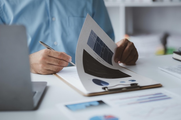 A business finance man is reviewing a company's financial documents prepared by the Finance Department for a meeting with business partners Concept of validating the accuracy of financial numbers