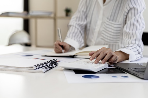 A business finance woman is reviewing a company's financial documents prepared by the Finance Department for a meeting with business partners. Concept of validating the accuracy of financial numbers.